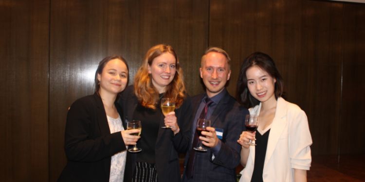4 people with drinks smile at the camera