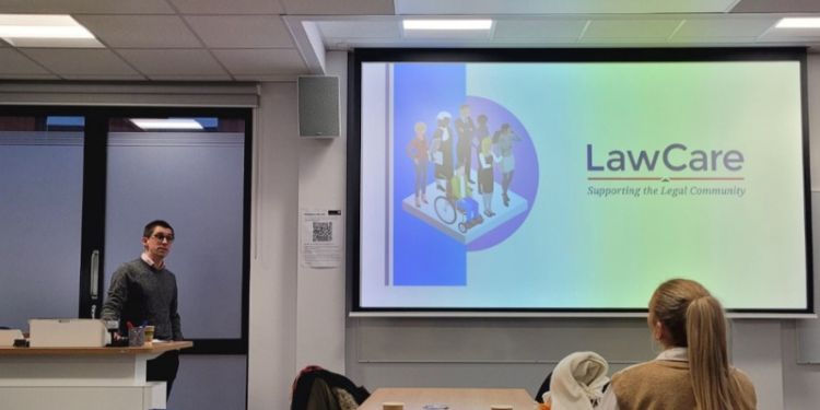 Man talks to audience in front of power point
