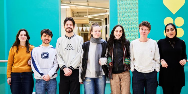 Group of young people in a row smile at camera