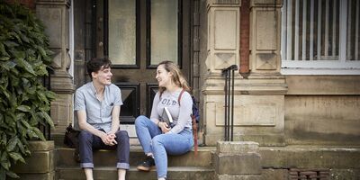 Two students sitting outside the School of Education