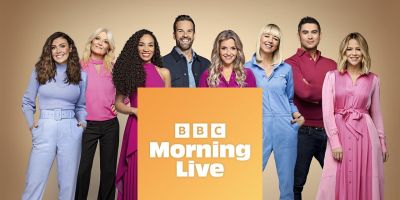 Eight BBC Morning Live show presenters stand in colourful outifts around an orange square with 