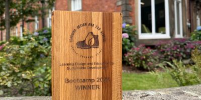 Bootcamp award in front of the School of Education building