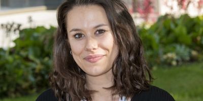 Woman with brown hair smiling at the camera.