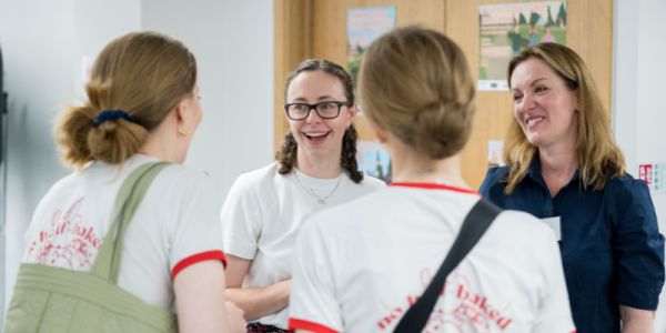 Dr Lewis and Dr Shaw talking to two people and smiling.
