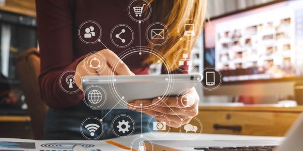 Person using tablet and laptop overlaid with graphic representing communication