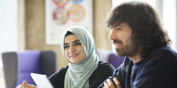 Two researchers chatting over a computer