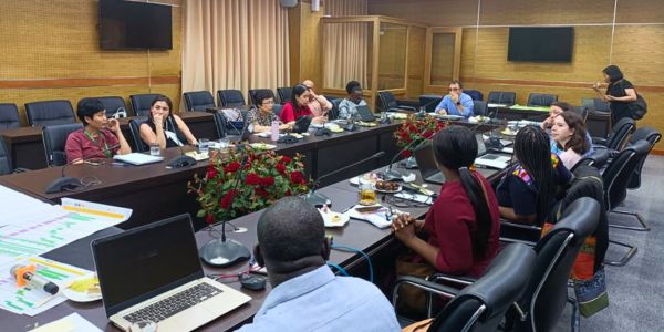 13 members of the RESPONSE project team are seated around a boardroom/conference table, some with laptops out, some in deep discussion.