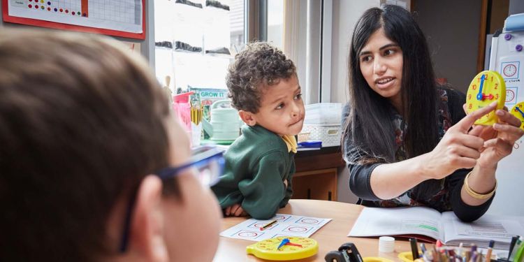 Children learning how to tell time with a teacher