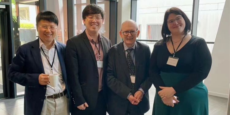Your sentence is almost correct but could benefit from slight rephrasing for clarity:

"Shuaihao (second from left) stands with his supervisors, (from left to right) Dr Zinian Zhang, Professor Gerard McCormack, and Dr Oriana Casasola. They are smiling.