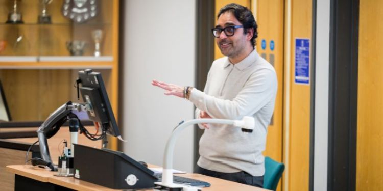 Neil standing behind a podium in the Moot Court, speaking and gesturing with his hands.