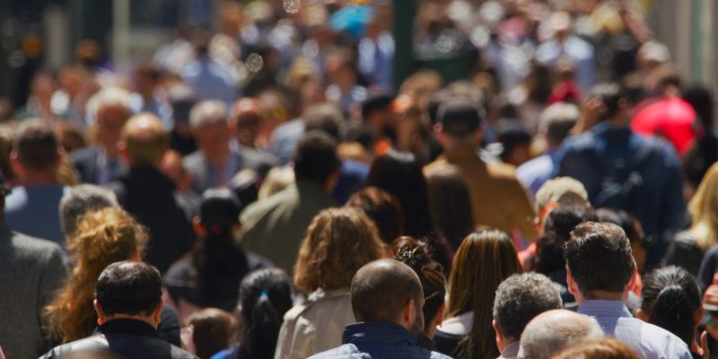 A crowd of people on the street, seen from behind